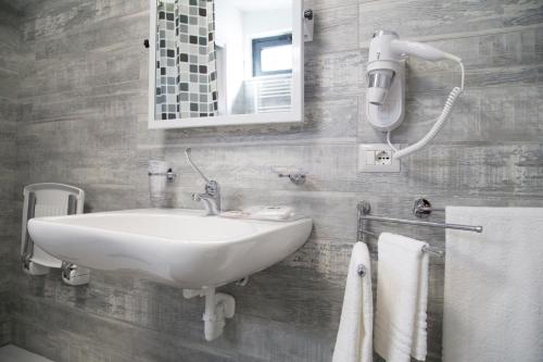 a bathroom with a sink and a mirror and towels at Il Teatro B&B in Marina di Gioiosa Ionica