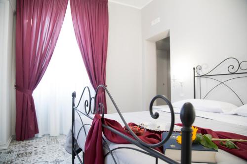 a bedroom with a bed with red curtains at Il Teatro B&B in Marina di Gioiosa Ionica