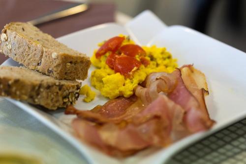 a plate of food with eggs bacon and toast at Hotel Ristorante Al Fiore in Peschiera del Garda