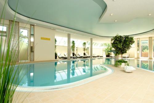 a large swimming pool in a building with a ceiling at Das Schokoladenhotel in Westerstede