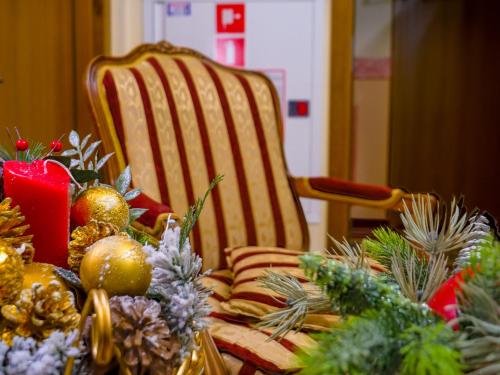 a table with a chair and christmas decorations on it at Pensjonat Zbójecki Dwór - ATRAKCYJNY PAKIET ŚWIĄTECZNY - blisko basenów termalnych i szlaków górskich in Bukowina Tatrzańska