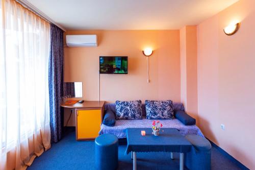 a living room with a couch and a table at Family Hotel Jemelly in Obzor