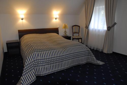 a bedroom with a bed with a blanket on it at Birutes Uostas in Šventoji