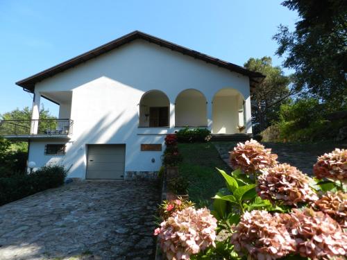 una casa blanca con flores delante en Casa del Sole, Villa indipendente isolata in area verde perfetta smart-working, en Riccò del Golfo di Spezia