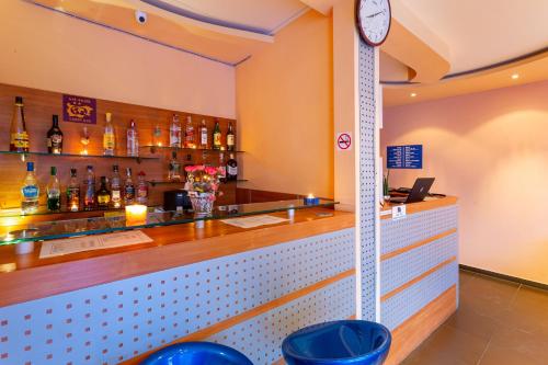 a bar with a clock on the wall at Family Hotel Jemelly in Obzor