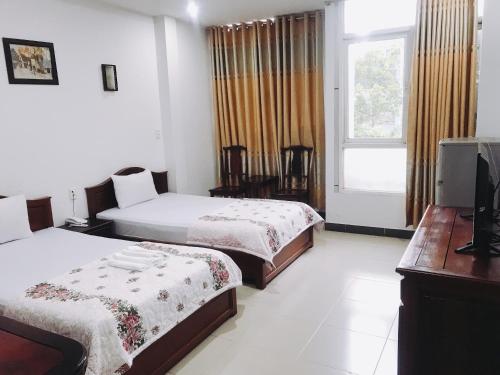 Una habitación de hotel con dos camas y un televisor. en Khách sạn Mai Lan, en Ho Chi Minh