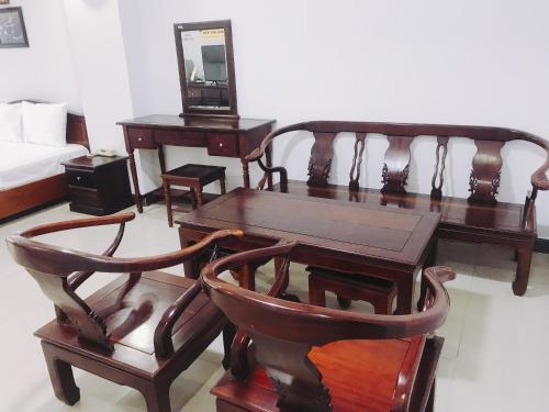 um quarto com uma mesa e cadeiras e uma cama em Khách sạn Mai Lan em Ho Chi Minh