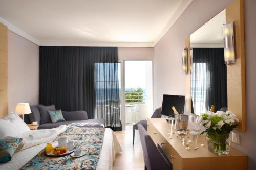 a living room with a couch and a table with flowers at Louis Ledra Beach in Paphos City