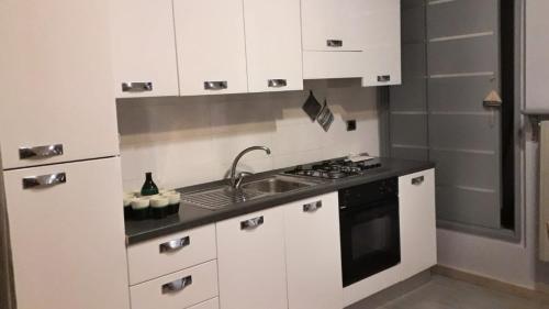 una cocina con armarios blancos y fregadero en MaPu', en Barletta
