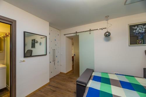 een slaapkamer met een kleurrijk bed en een spiegel bij Nono Mario in Piran