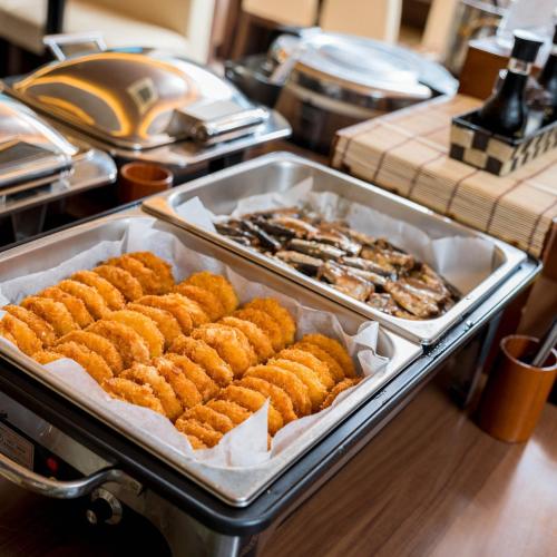 a buffet with several trays of food on a table at Super Hotel Izumo Ekimae in Izumo