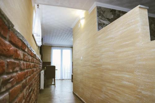 a hallway with a brick wall and a window at Hotel ZRINSKI in Koprivnica