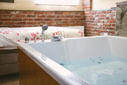 a bathroom with a tub with water coming out of it at Hotel ZRINSKI in Koprivnica