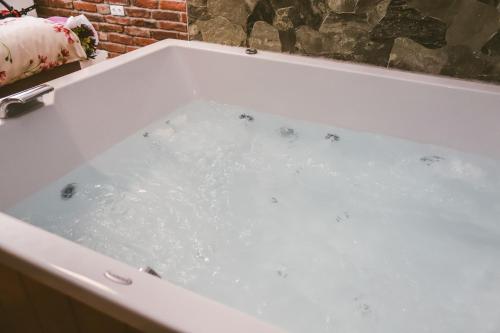 a bath tub filled with water in a bathroom at Hotel ZRINSKI in Koprivnica
