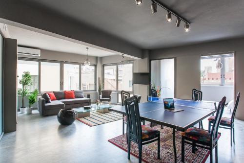 a living room with a table and chairs and a couch at Artists’ favorite Spacious Loft near Acropolis!! in Athens