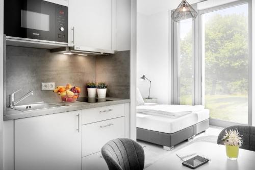 eine Küche mit einem Bett und einem Waschbecken in einem Zimmer in der Unterkunft Favorit Serviced Apartments in Ludwigsburg