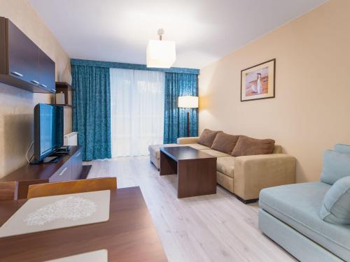 コウォブジェクにあるAquaBaltic Apartments Aquariusのソファとテレビのあるリビングルーム