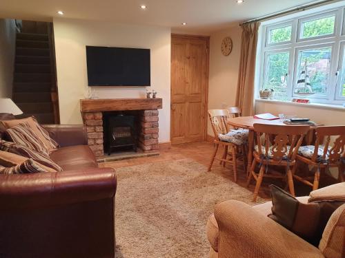 a living room with a fireplace and a table at The Coach House Holiday Cottage, Southport in Southport