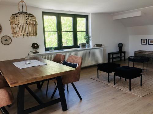 a living room with a wooden table and chairs at Solgård - Licht über den Dächern Tönnings in Tönning