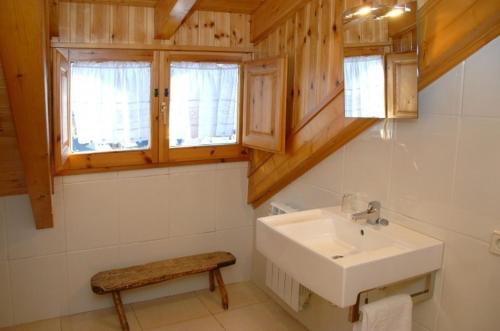 baño con lavabo, banco y ventanas en Casa Rural Casa Colom, en Espot