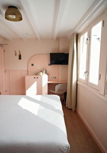 a bedroom with a white bed and a window at The Times Hotel in Amsterdam