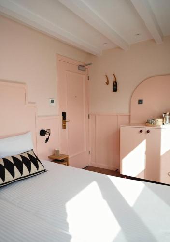 a bedroom with a bed and a kitchen at The Times Hotel in Amsterdam