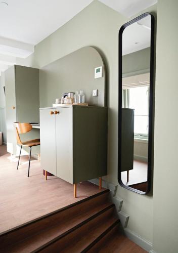 a bathroom with a mirror and a dresser and a stair at The Times Hotel in Amsterdam