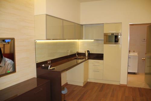 a kitchen with white cabinets and a sink and a mirror at Apartment in Center of Odessa in Odesa