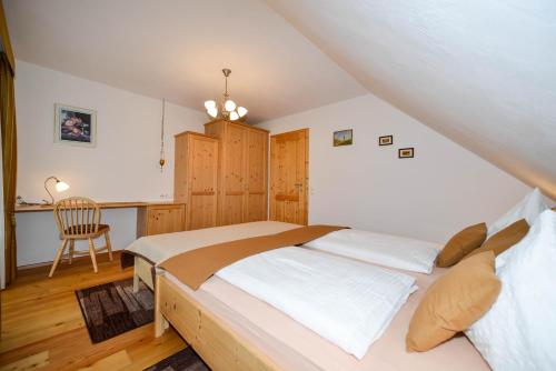 1 dormitorio con cama, escritorio y silla en Bauernhof Unterkrug en Gnesau