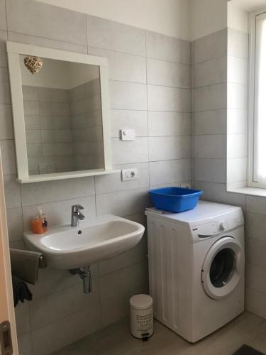 een badkamer met een wasmachine en een wastafel bij Appartamento Marte in Arco