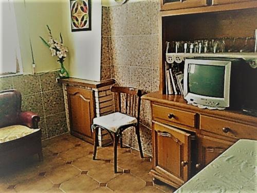 um quarto com uma secretária, uma televisão e uma cadeira em Casa rural 47, La Acebosa, San Vicente de la Barquera em La Acebosa