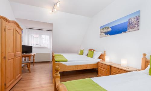 a bedroom with two beds and a desk with a computer at Hotel Landgasthof Hölzer in Fröndenberg