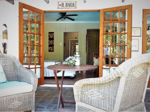 a room with two chairs and a table and a bed at Khashamongo B & B in Somerset West