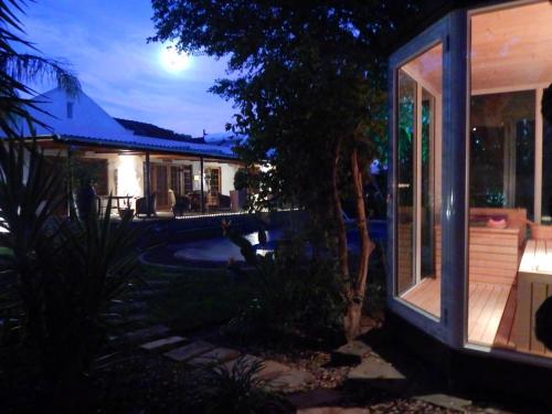a house at night with a pool in front of it at Khashamongo B & B in Somerset West