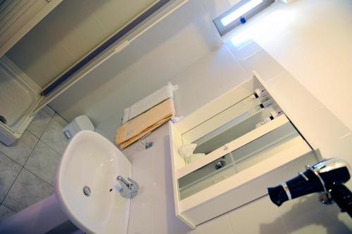 a bathroom with a white sink and a mirror at Maison De Lussy in Piazza Armerina