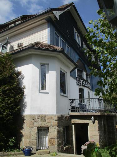 a white building with a balcony on top of it at Villa Tannerhof in Braunlage
