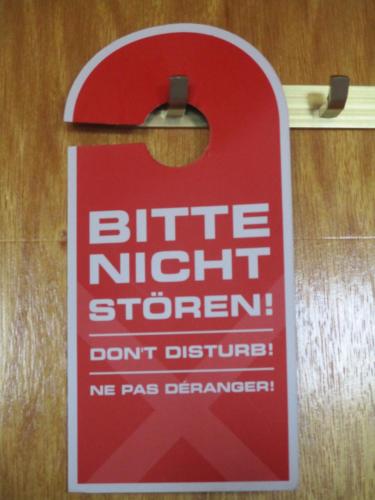 a red sign hanging on a wooden wall at Villa Tannerhof in Braunlage