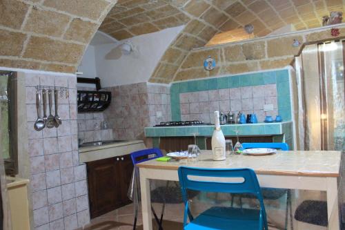 a kitchen with a table and blue chairs in it at Bilocale Dillo alla luna in Gallipoli