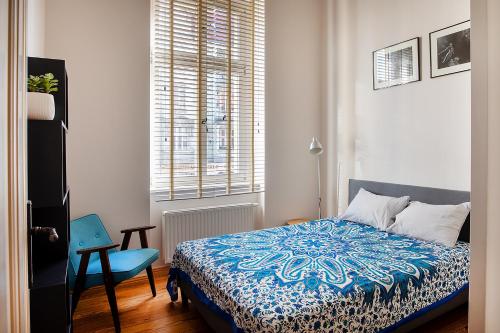 um quarto com uma cama, uma cadeira e uma janela em Movie Apartment Jeżyce em Poznań