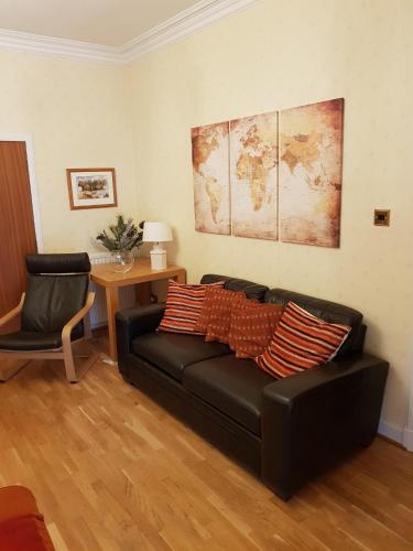 a living room with a black couch and a table at Hamilton House in Dumfries
