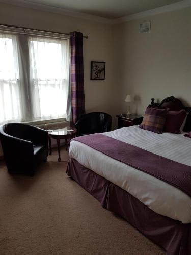 a bedroom with a large bed and a window at Hamilton House in Dumfries