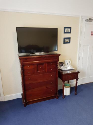 a flat screen tv on a dresser in a room at Hamilton House in Dumfries