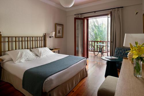 a bedroom with a bed and a living room at Parador de El Hierro in Las Casas