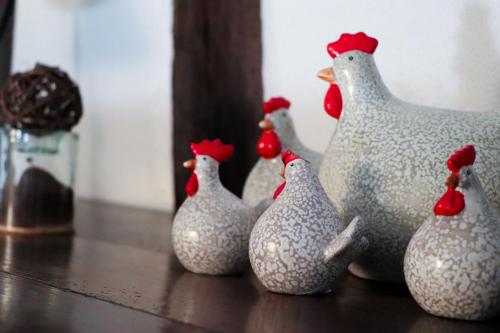 a group of rubber chicken figurines sitting on a table at Sous les toits du Zinc - Climatisé in Colmar