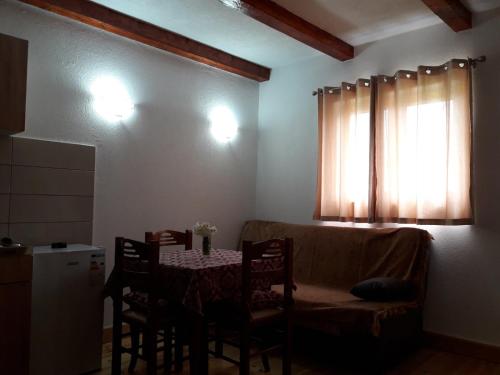 a room with a table and a couch and a window at Domaćinstvo Krstajić - Rural holiday in Žabljak