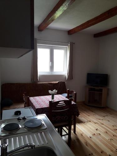 a living room with a table and a couch at Domaćinstvo Krstajić - Rural holiday in Žabljak