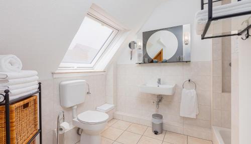 a bathroom with a toilet and a sink and a window at Hotel Landgasthof Hölzer in Fröndenberg