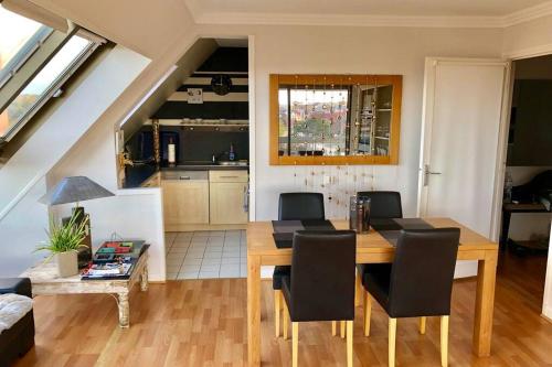 une cuisine et une salle à manger avec une table et des chaises en bois dans l'établissement Appartement triangle d'or terrasse garage fermé, à Le Touquet-Paris-Plage