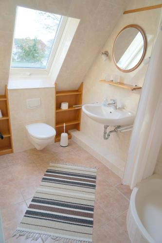 a bathroom with a sink toilet and a window at Haus Ruh di ut Wohnung LUV in Kellenhusen