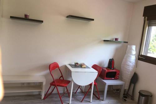 une pièce avec deux chaises et une table et un appareil rouge dans l'établissement Studio proche du lac-Triangle d'or, à Annecy